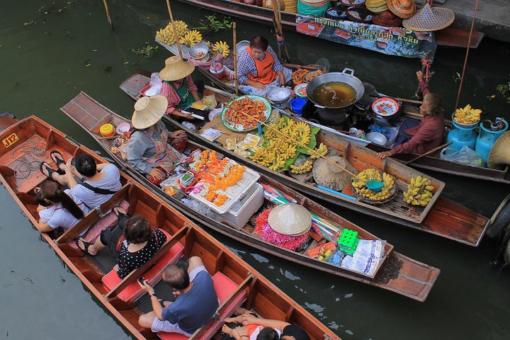 Wooden long-tail boats loaded with goods on the canal at Damnoen Saduak Floating Market near Bangkok